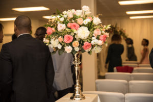 elevated coral floral arrangement for entrance to ceremony aisle