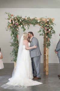 bride-groom-kiss-ceremony-arbor