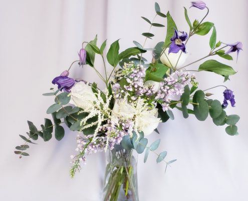 asymmetrical design of white and purple flowers surrounded by greenery designed by durham florist poppy belle floral design 