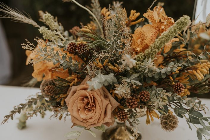 Centerpiece with greens dusty coral and texture for boho fall floral designed by durham florist poppy belle floral design