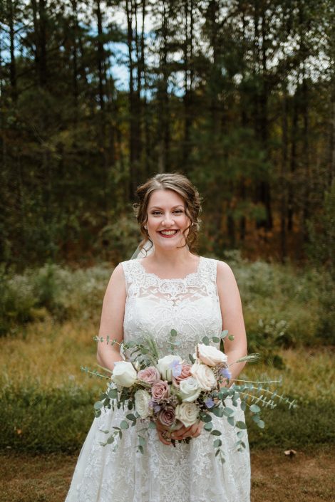 Bride holding bouquet of blush ivory and white with eucalyptus designed by durham florist poppy belle floral design