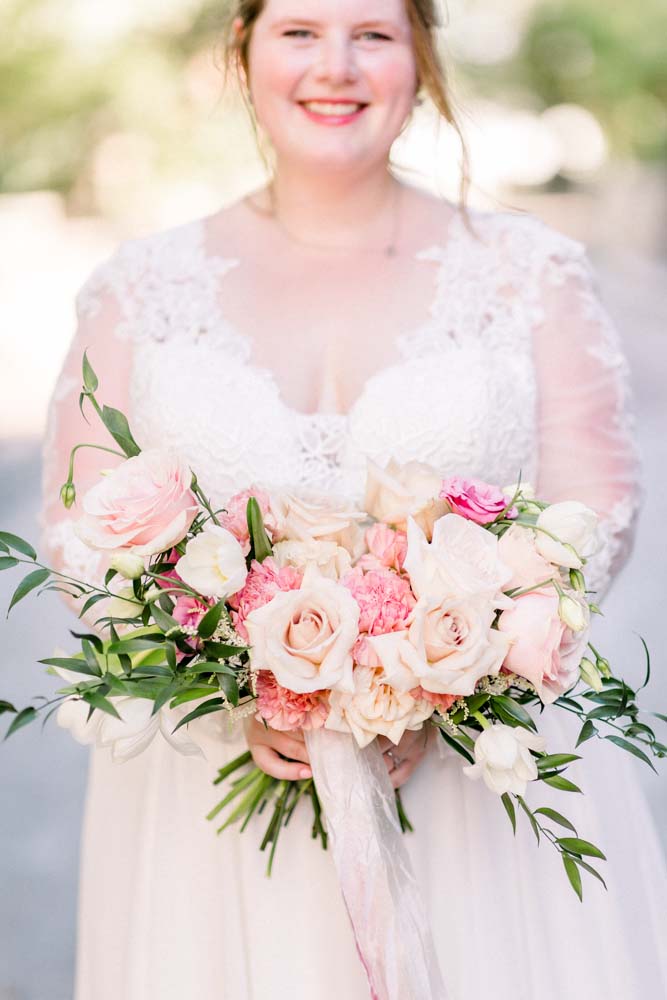 Bride in lace long sleeve wedding dress holdingblush and cream bridal bouquet by durham florist poppy belle floral design