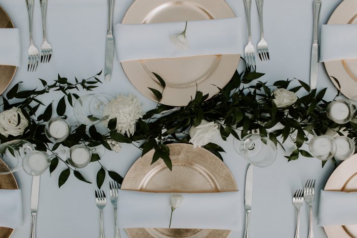 White blooms and greenery garland as centerpiece of long head table designed by durham florist poppy belle floral design