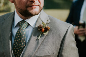Groom wearing a unique textural fall boutonniere. Designed by Poppy Belle, Durham florist
